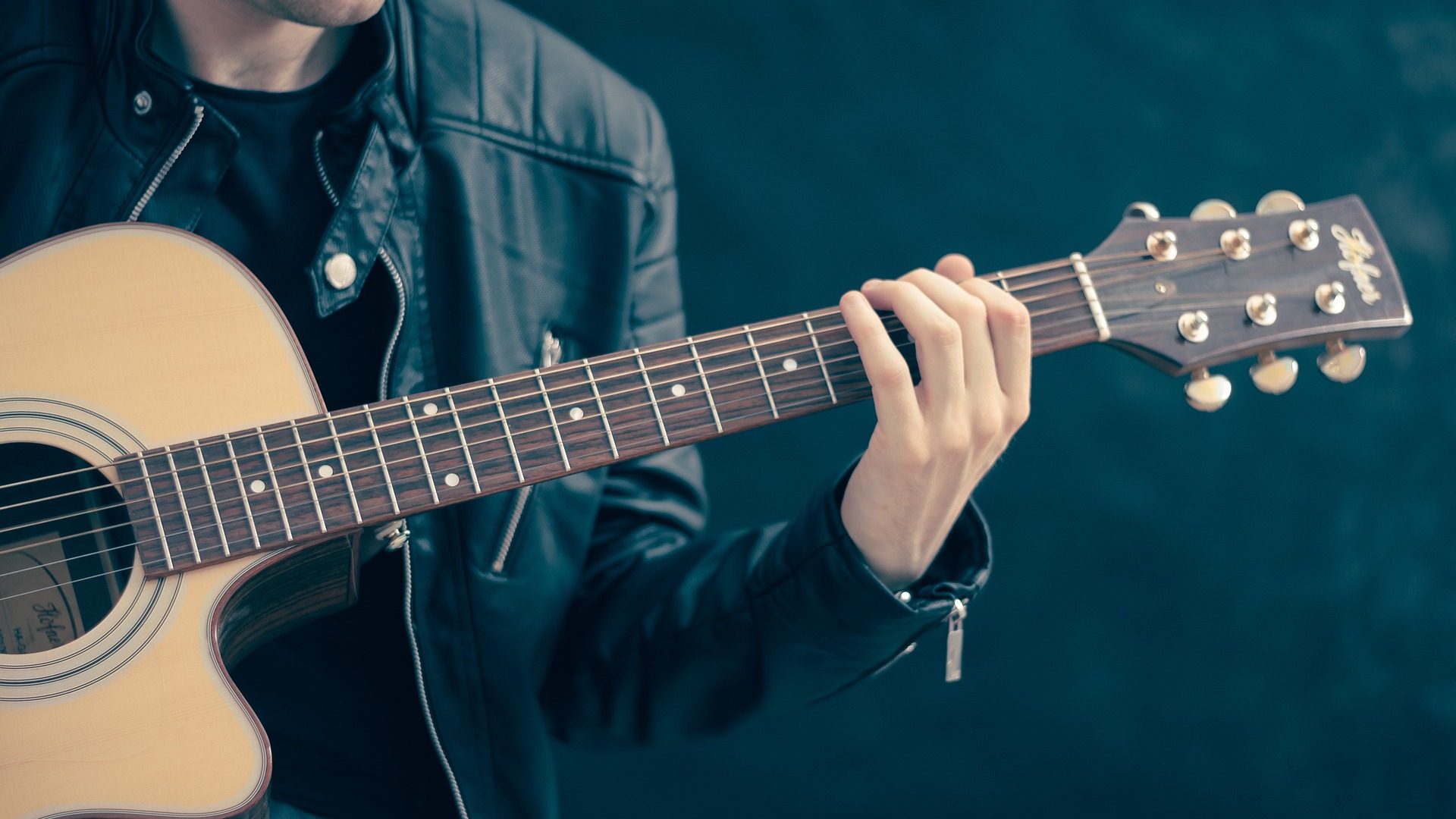 Foto eines Gitarrespielers - Auch Musiker benötigen eine Versicherung für Künstler